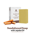 Sandalwood soap with packaging and jojoba oil sticks on a white background